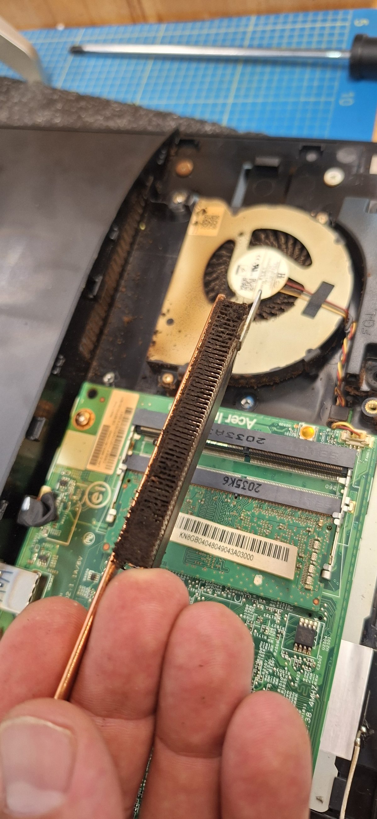 Stark verstaubter, mit brauner Staubschicht zugesetzter Kühlkörper eines Laptops vor der Reinigung