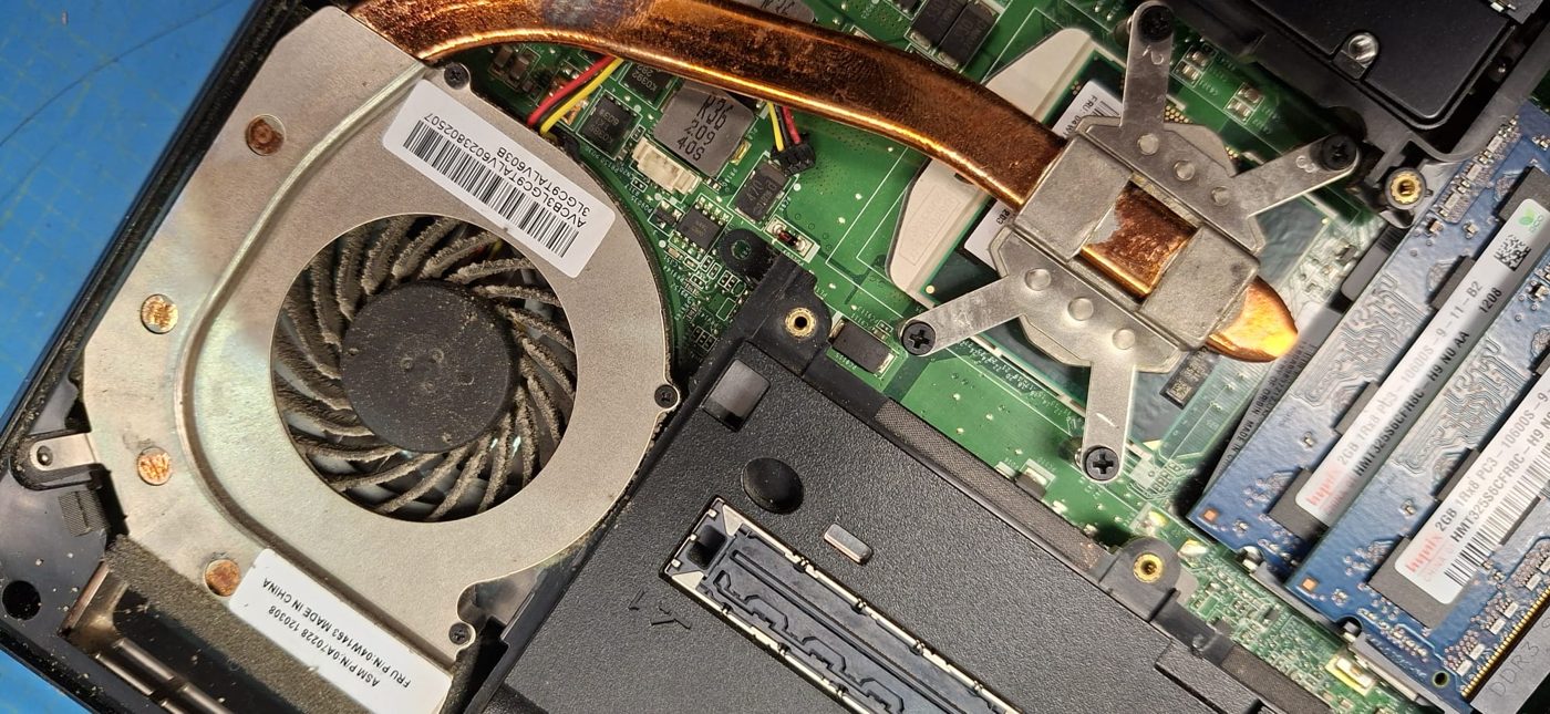 ThinkPad-Lüfterrad vor der Reinigung: jede Lüfterschaufel ist von einer dichten grauen Staubschicht überzogen